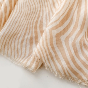 Close-up of zebra pattern scarf showing soft coffee and white fabric with frayed edges