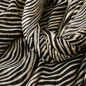 Macro shot of breathable zebra striped fabric showing light translucent silk texture