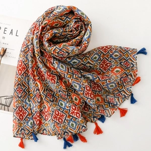 Detail of bohemian geometric print scarf with colorful fringe tassels on white background