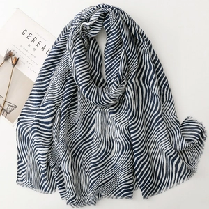 Detail of blue and white zebra pattern scarf with soft fringe edges on white background