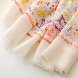 Detail shot of light floral print scarf with soft fringe edges and premium cotton feel