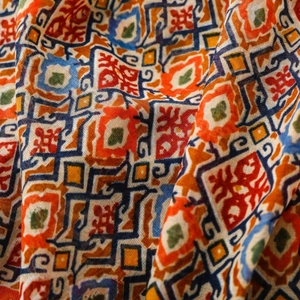 Close-up of bohemian silk scarf featuring geometric tribal patterns and vibrant colors