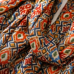 Close-up of Bohemian geometric floral scarf with colorful tassel and ethnic pattern