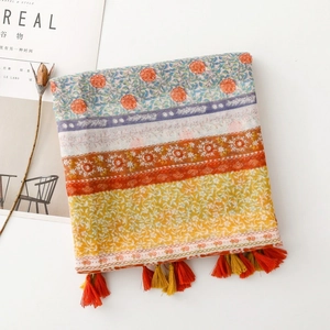 Close-up of Bohemian floral print scarf with orange and yellow tassels and fringe detail