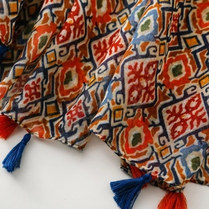 Close-up of bohemian scarf with geometric prints and bicolor fringe tassels