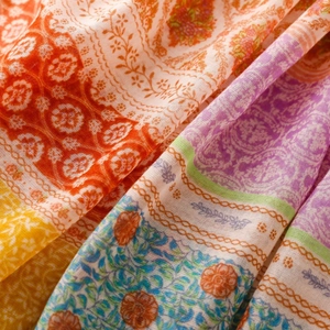 Macro view of Bohemian scarf with wheat patterns and colorful ethnic tassel details