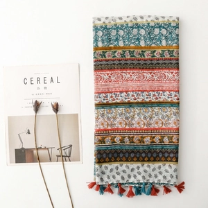 Bohemian floral pattern scarf with vintage stripes and tassel trim on white surface
