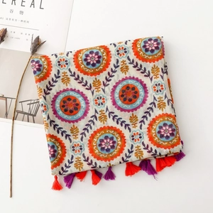 Détail du motif floral mandala bohème et pompons colorés sur un châle en coton et lin
