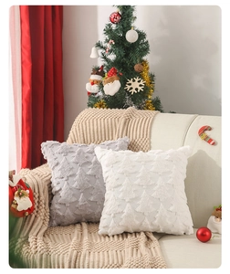 Detailed view of plush Christmas tree patterns on textured grey and white pillow covers