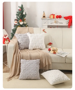 Detail of Christmas tree textured plush pillows and cream knitted tassel throw blanket