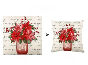 Detail of Christmas pillow cover with poinsettia flowers and JOY lettering on linen fabric