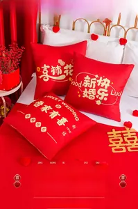 Macro shot of red wedding cushions with gold floral embroidery and Chinese characters