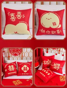 Detail of red plush wedding pillow covers with gold Xi characters and festive patterns