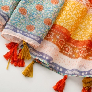 Close-up of bohemian scarf detail showing wheat ear print and colorful fringe tassels