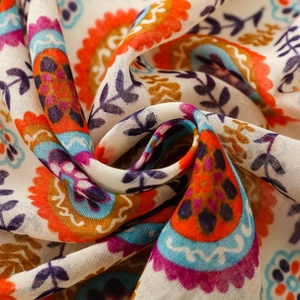 Macro d'un motif floral bohème vibrant sur un tissu d'écharpe ethnique léger et doux