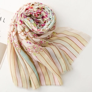Detail of floral stripe cotton scarf with delicate fringed edges and pastel patterns