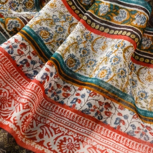 Close-up of bohemian floral scarf fabric with intricate patterns and soft fringe detail
