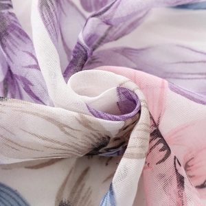 Macro detail of lightweight floral voile fabric showing blue and purple petal patterns