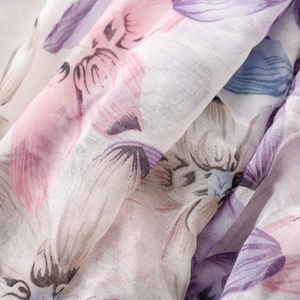 Macro detail of lightweight floral scarf with soft blue and purple flower patterns