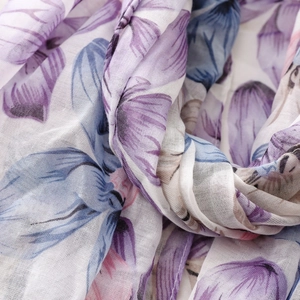 Macro shot of breathable floral voile scarf showing purple flower print and grid texture