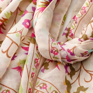 Detailed macro view of lightweight floral print fabric showing weave texture and pastel flowers