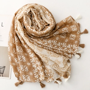 Detail showing soft cotton-linen scarf with geometric floral print and tassel edges