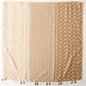 Detail of bohemian geometric shawl featuring earth-toned floral patterns and fringe trim