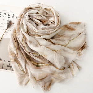 Detail of marble pattern cotton scarf with gold foil accents and frayed edge finish