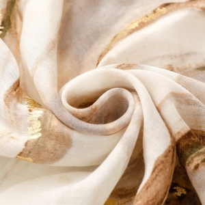 Detailed close-up of marble pattern scarf with gold foil accents and frayed edges