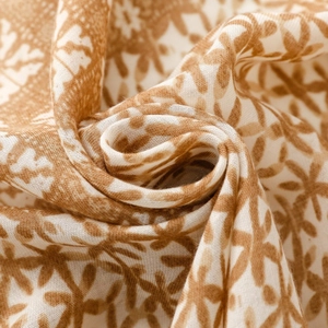 Close-up of geometric floral print on soft cotton-linen shawl with tassel details