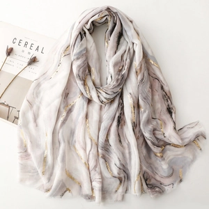 Elegant marble print scarf with gold foil accents and raw edges on a white background