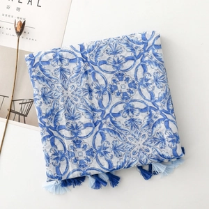 Detailed close-up of blue porcelain floral print and colorful tassels on fabric