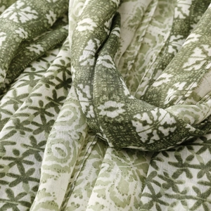 Detailed macro view of dark green floral print linen feel scarf with elegant tassels