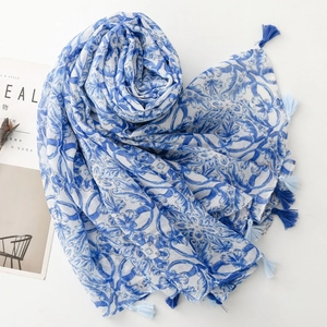 Detail of blue and white porcelain pattern scarf with delicate tassels and soft fabric