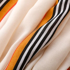 Close-up of striped cotton-linen shawl with vibrant red, orange, and black color blocks