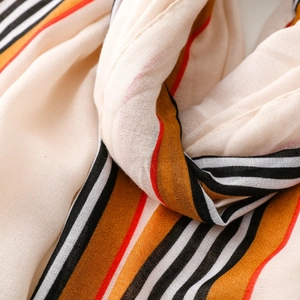 Macro detail of striped cotton-linen scarf fabric showing soft texture and rich colors