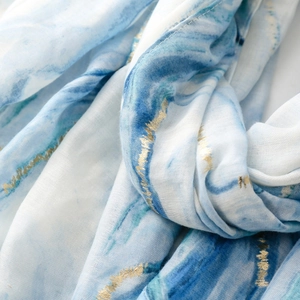 Detail of marble pattern scarf with gold foil accents and delicate fringe texture
