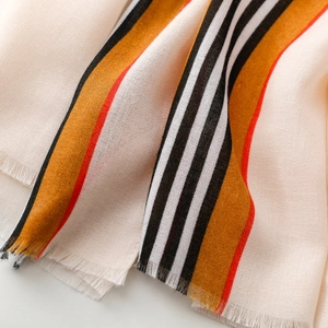 Close-up of soft striped scarf showing fine fabric texture and short fringe details