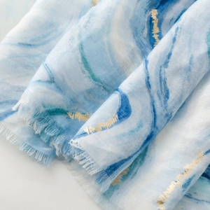 Close-up of blue marble texture cotton linen scarf with elegant gold foil accents