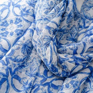 Close-up of blue porcelain pattern on breathable fabric with delicate tassel detail