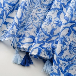 Detail of blue and white bohemian floral print fabric with decorative tassels