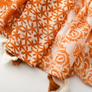 Detail view of cotton-linen feel scarf featuring geometric star patterns and fringe trim