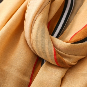 Close-up of ginger yellow striped linen-touch shawl showing soft texture and fine stitching