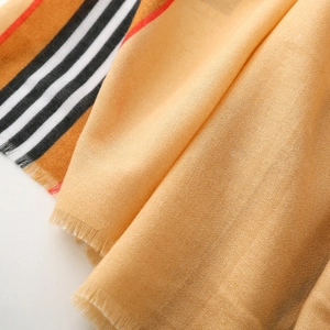 Close-up of soft camel stripe scarf featuring classic texture and delicate fringe edge