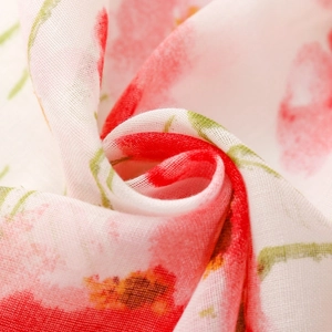 Close-up van lichtgewicht voile sjaalstof met rode bloemen en kwastjes details