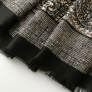 Close-up of vintage paisley and grid pattern shawl with soft fabric and fringed edges
