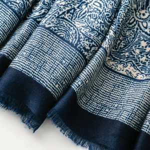 Detailed view of paisley patterns and soft fringe on this blue navy cotton linen scarf