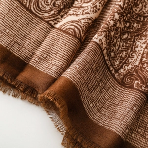 Macro detail of paisley and check patterns on vintage tassel scarf shawl fabric