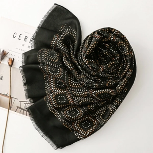 Detail of vintage geometric dot pattern on a black shawl with soft fringe edges