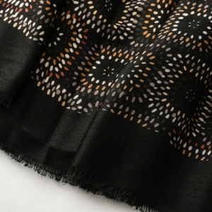Detail of vintage geometric kaleidoscope pattern on black cotton linen scarf with soft fringe